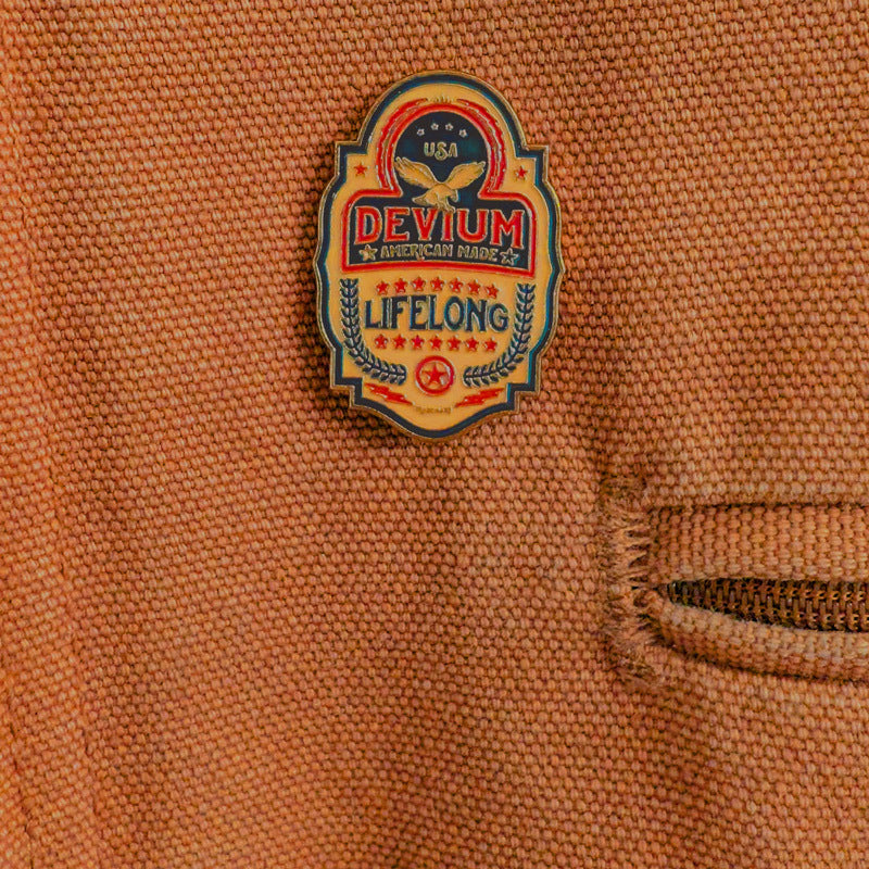 A yellow, red, and blue pin on a fabric background.