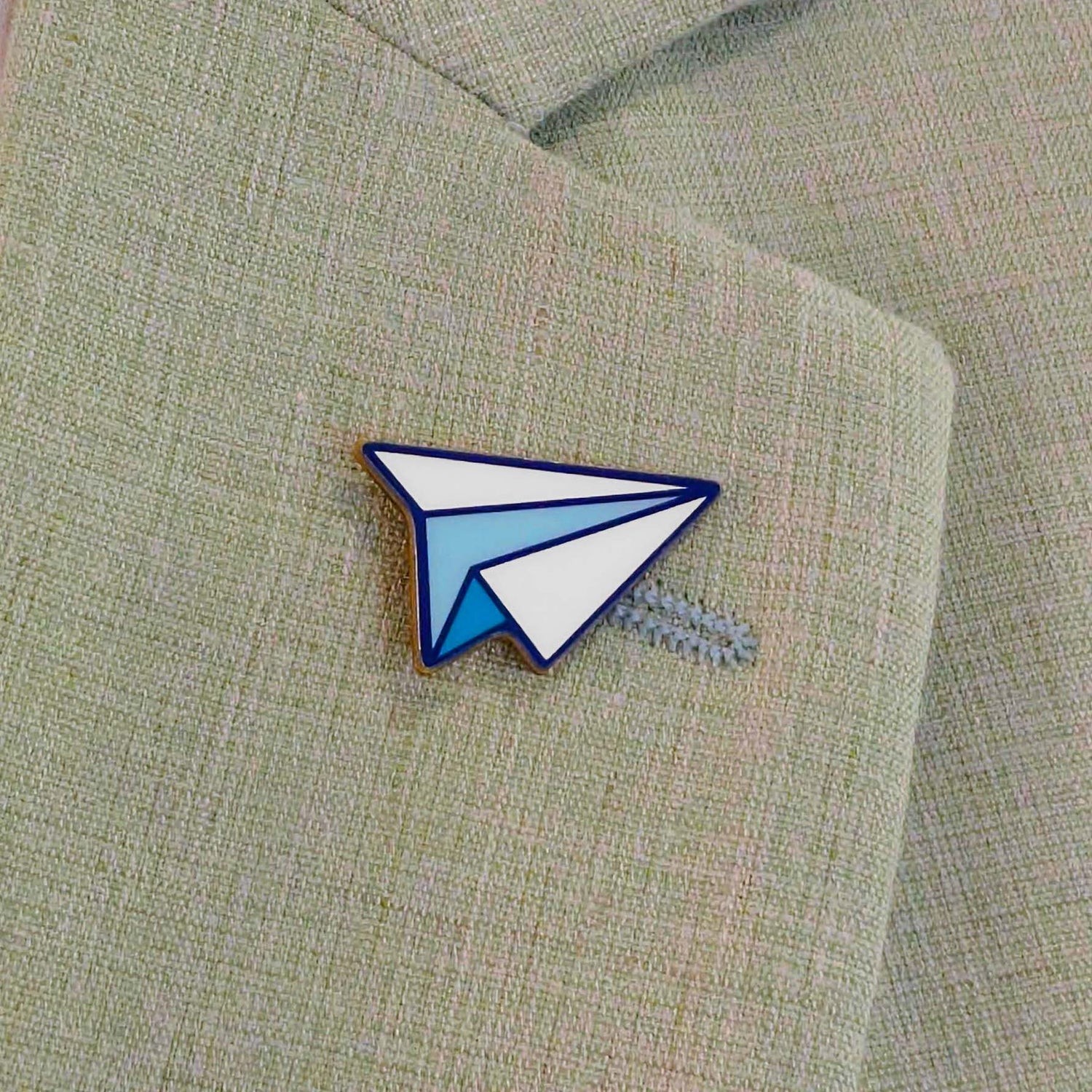 Custom lapel pin showing a minimalistic paper airplane.